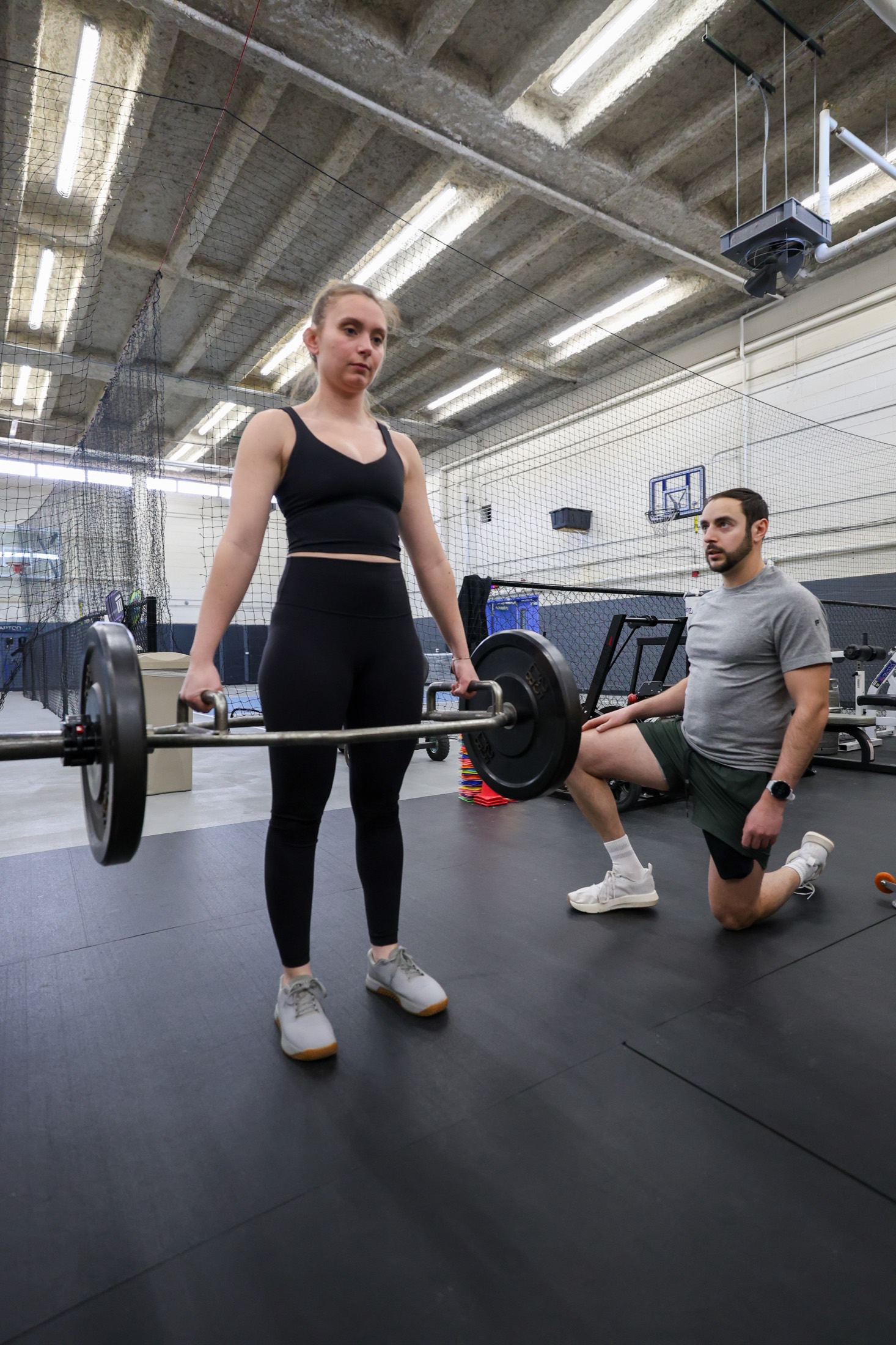 Client performing a trap bar deadlift with coach guidance